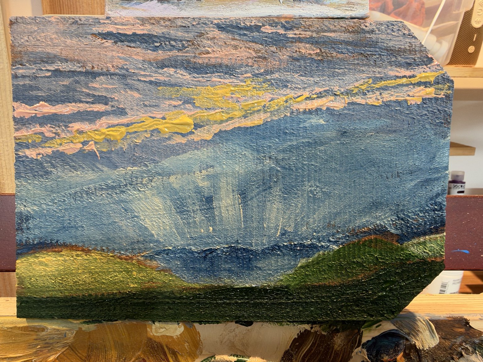 Textured blue hills and golden light painted on a cedar board